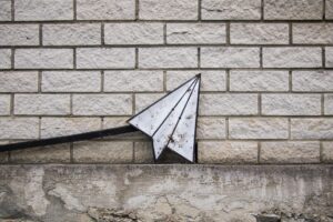 Paper Airplane sign against a wall