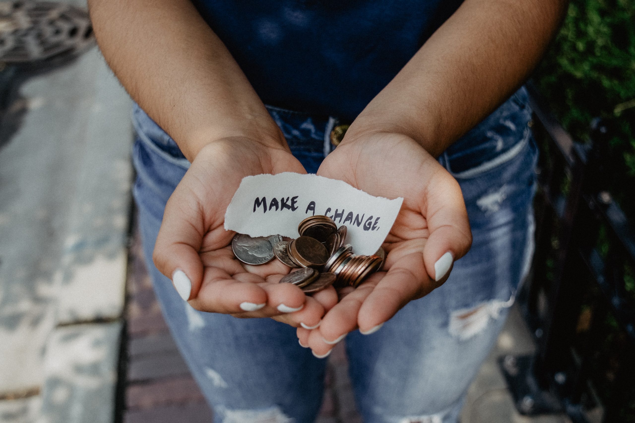 Hands holding coins and a note that says "make a change"